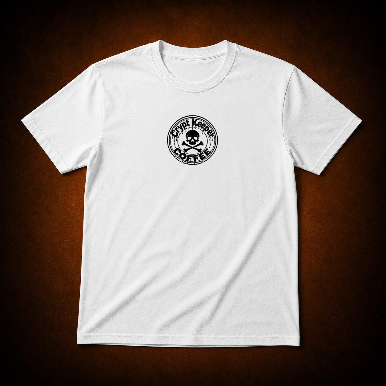 A white short-sleeve crewneck t-shirt with a circular black graphic on the left chest reading 'Crypt Krew COFFEE' around a skull and crossbones, displayed against a dark brown vignette background.